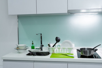 A mountain of dirty dishes in the kitchen sink. Mess in the house