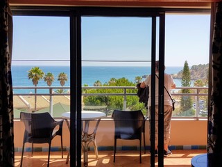 Hotel beach woman display balcony rear relaxing view.
