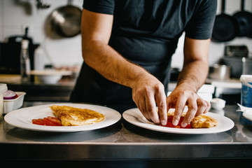 Professional chef working in restaurant kitchen and making delicious traditional food.