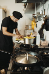 Professional chef working in restaurant kitchen and making delicious traditional food.