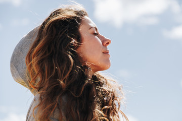 Young woman with hood resting while standing breathes deeply