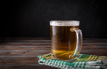 alcoholic beverage, light barley beer on a checkered green towel on a dark wooden