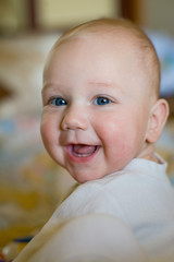 Caucasian toddler cute infant baby boy smiling with first teeth