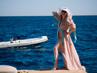Cute caucasian woman in a white hat resting tourist on the shores of the picturesque Red Sea in Egypt