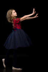 Side View of Pretty Girl in Tutu Dress Holding Hands in front of