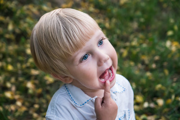 Cute funny caucasian toddler kid child boy with finger in mouth