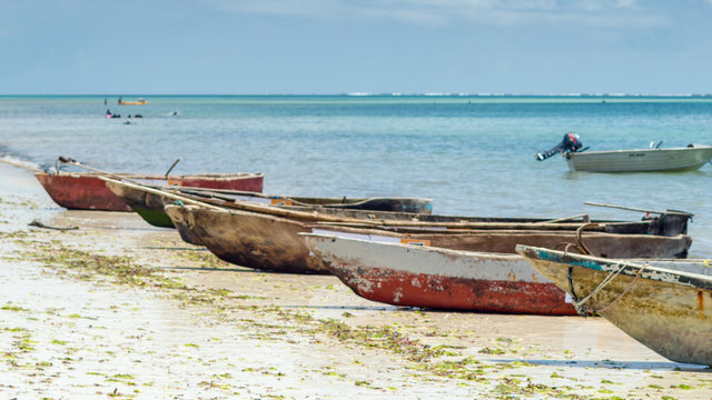 Fisher mans canoes during low tide at the edge of the pcean