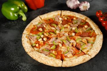 pizza with pepperoni, mushrooms, pepper on a black background