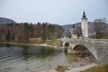 Autumn time at the Stone bridge with the Church of San John, Lake Bohinj.