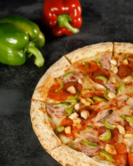 pizza with pepperoni, mushrooms, pepper on a black background