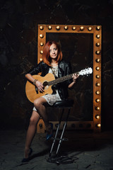 Fototapeta na wymiar young girl with red hair with an acoustic guitar