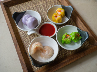 Dim Sum set served with special dipping sauce on a wooden tray