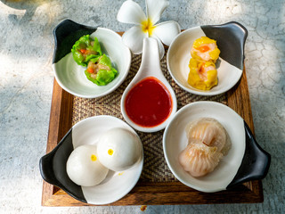 Dim Sum set served with special dipping sauce on a wooden tray