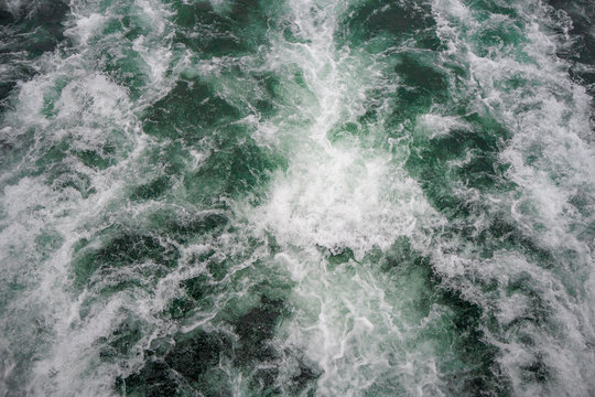 Beautiful scene of fresh flowing emerald water and spray from botom of ferry boat for background , copy space