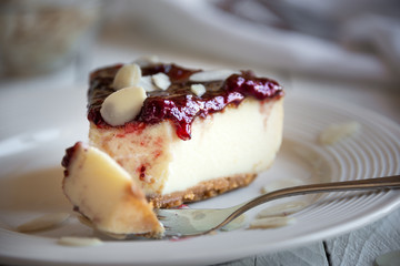 Homemade delicious cheesecake with fruit jam and almonds