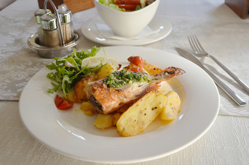 Pan fried fish fillet with potatoes and salad.