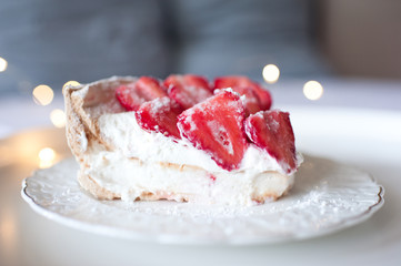 Big piece od strawberry cake on white vintage plate on table in room over glowing light closeup. God morning. Breakfast.