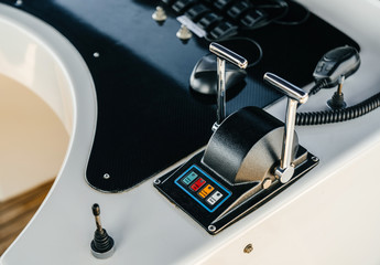 Levers of control of a marine yacht close-up. Main post with a ship control panel and color marks.