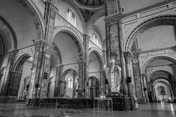 Cuenca, Ecuador, November 2013: Interior of the city's cathedral with it's stained glass windows, arches, marble columns and floors, and colonial decorations.