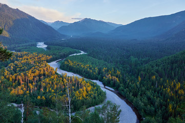 Obraz premium River valley in the forest surrounded by mountains.