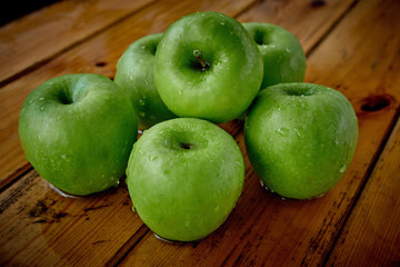 green apples on the table after rain
