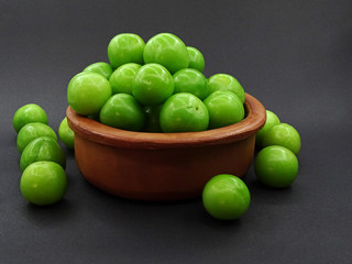 Green plums in a pottery bowl                               