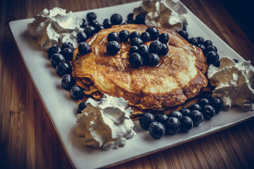 Pancakes with blueberries, cream and maple syrup