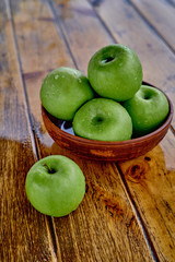 green apples on the table after rain