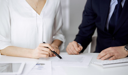 Unknown businessman and woman discussing contract in office. closeup.Business people or lawyers working together at meeting. Teamwork and partnership