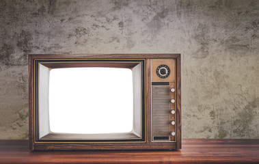 Retro old television on wooden table in front of concrete wall background, classic TV with cut out screen