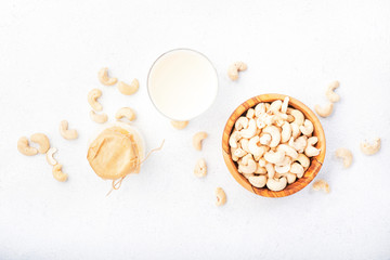 Fototapeta na wymiar Vegan Cashew nut milk in bottles, closeup, white table background. Non dairy alternative milk. Healthy vegetarian food and drink concept. Copy space