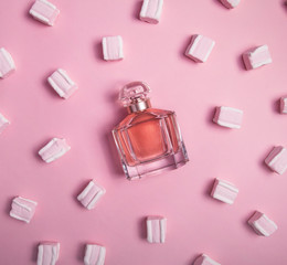 Sweet perfume on pink background with marshmallow. Fancy Fragrance for women