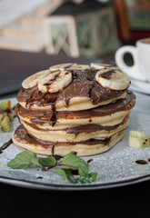 Breakfast. Pancakes with chocolate and banana and coffee