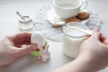 Healthy breakfast served on white dresser scarf with hand holding silver spoon