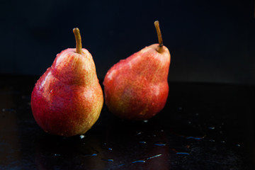 red pear on a dark background in a low key