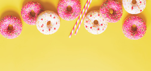 Obraz premium Flat lay with pink donuts or doughnuts pattern, vertical, on yellow background