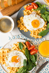 Fried egg, spinach, waffles and cup of coffee espresso on white background, flat lay
