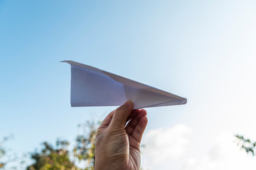 hand holding paper plane