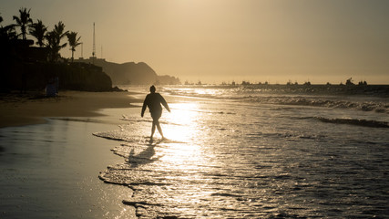 Girl walking along the beach in Mancora
