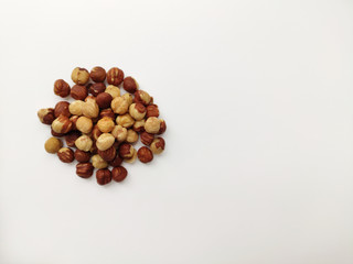 A handful of hazelnuts on a white background on the left.