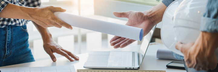 engineer Hand Drawing Plan On Blue Print with architect equipment discussing the floor plans over...