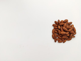 A handful of almonds on a white background on the right.