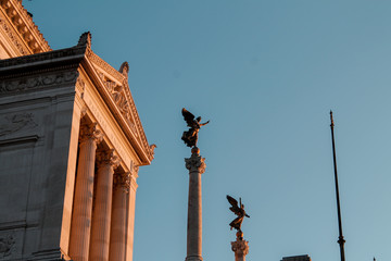 Fototapeta na wymiar statues, Monument to Victor Emmanuel II, vittoriano at sunset, against the blue sky, Rome, Italy