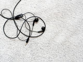 Entertainment and taste concept. Black portable headset on a gray background. Headphones In-Ear.