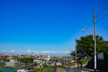 青空と坂の下の住宅街
