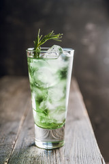 Sweet tequila based green cocktail with tarragon and rosemary. Selective focus. Shallow depth of field.
