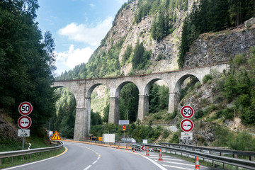 A road and an old train bridge in Chamonix, France. Perfect moment in alpine highlands. Mont-Blanc...