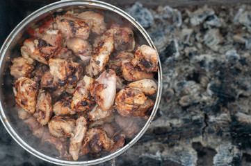 Picture of a kebabs in a large pan are in an extinct brazier