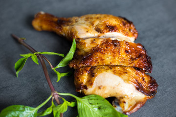 Grilled chicken fillets on black slate plate serve on concrete background