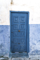 a blue street with multicolored doors in Morocco photographed on a Sunny day